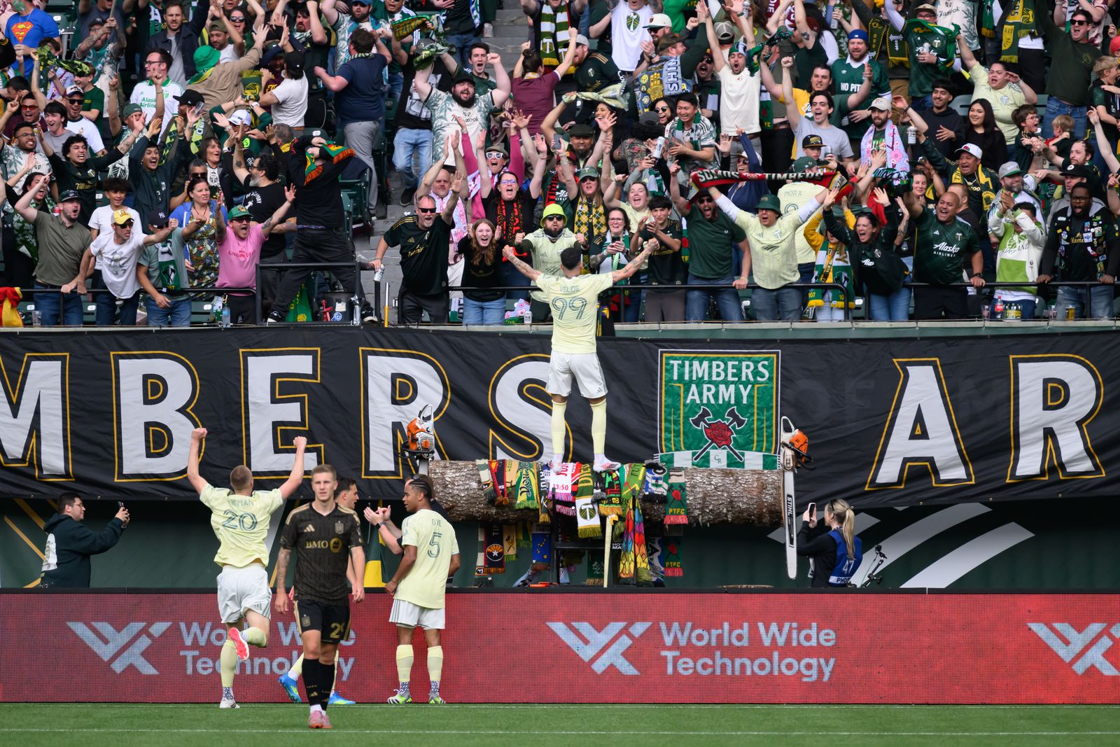 MLS LAFC soccer player stands on the railing with arms raised in celebration against Timbers in 2026.