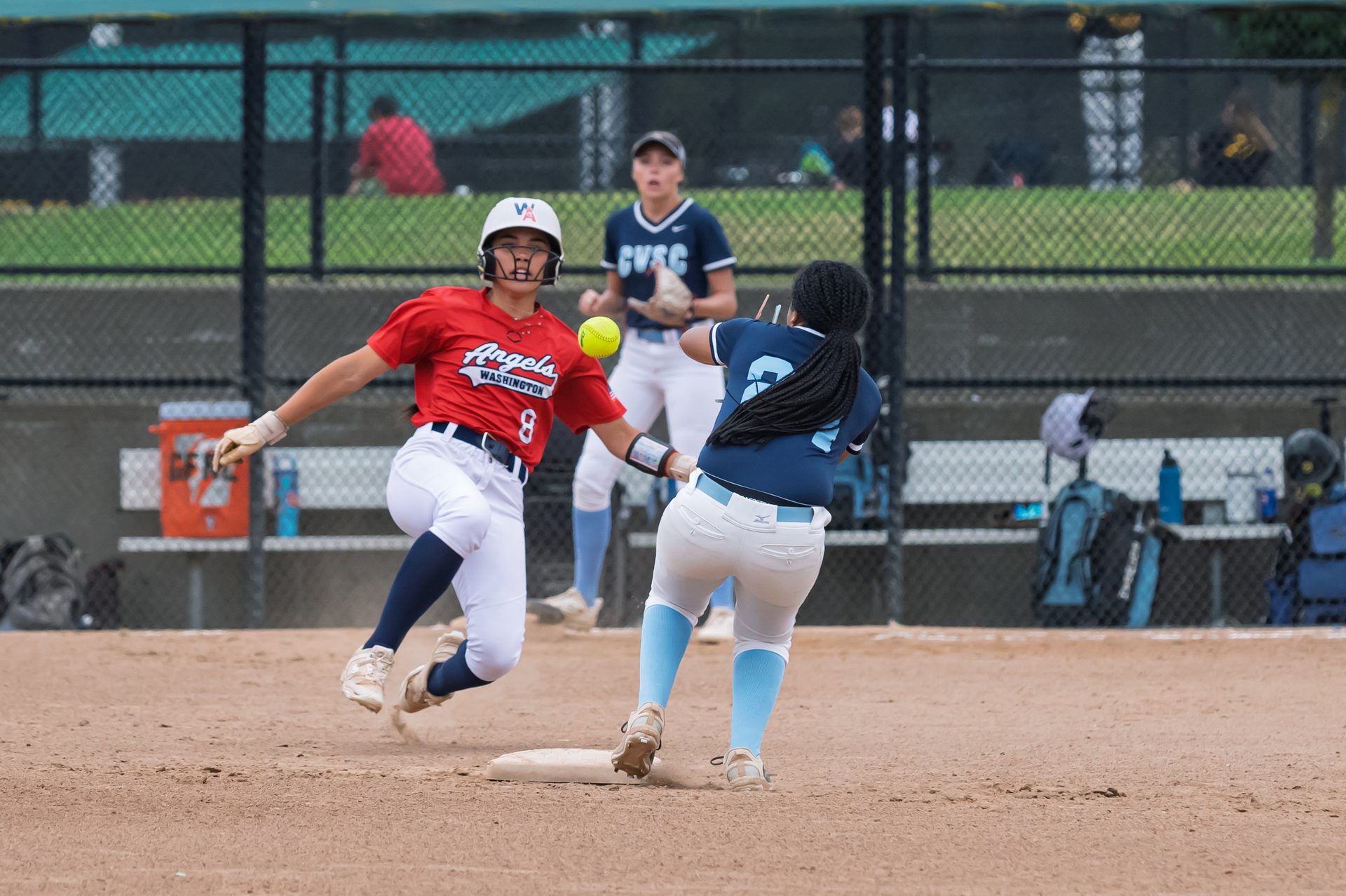 A runner sprints hard toward the bag just as the throw arrives for the fielder to make the play. 2026 TC World Series Softball, Portland Oregon, 2026.