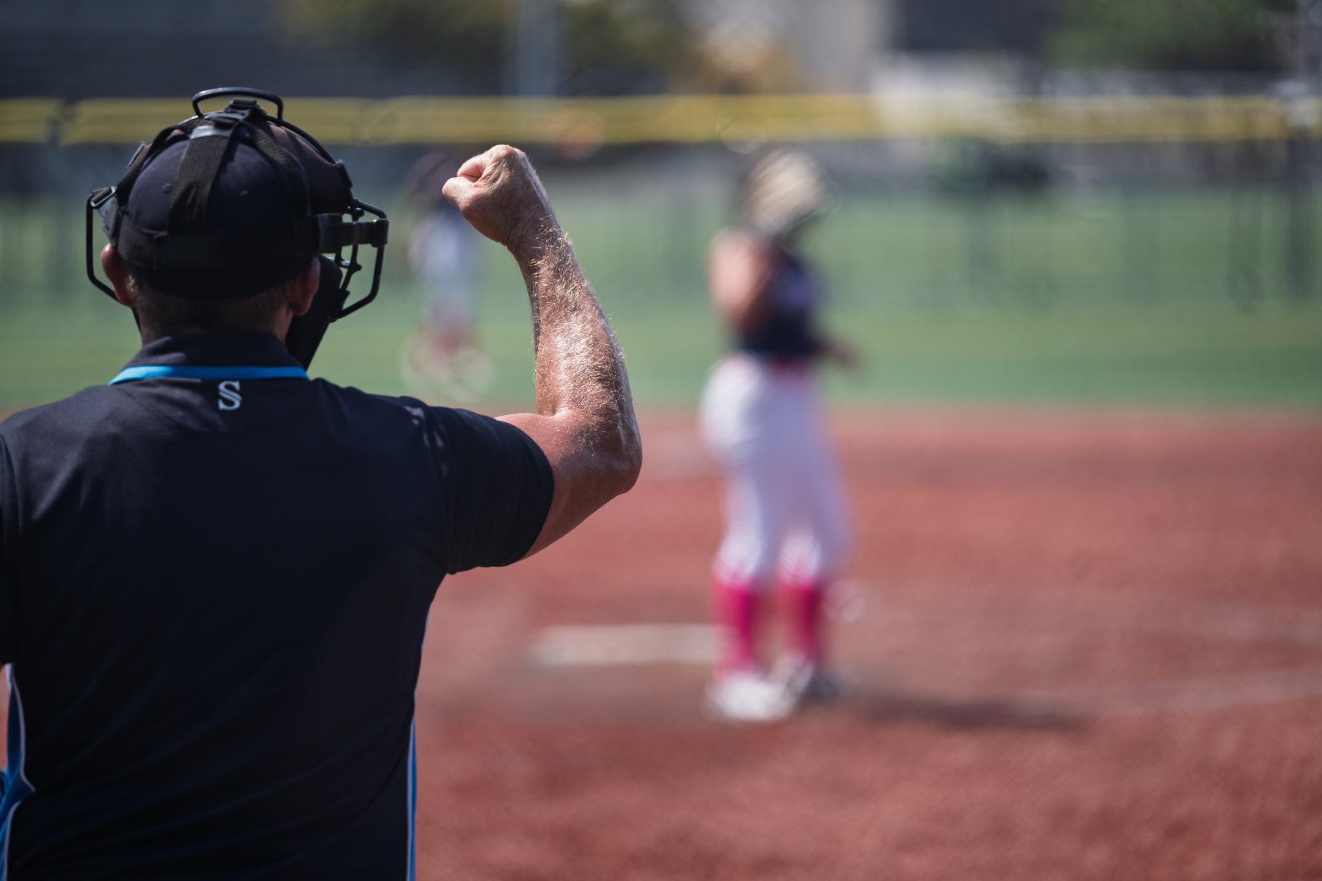 An umpire pumps a fist to make the call while a player waits out on the infield. 2026 TC World Series Softball, Portland Oregon, 2026.