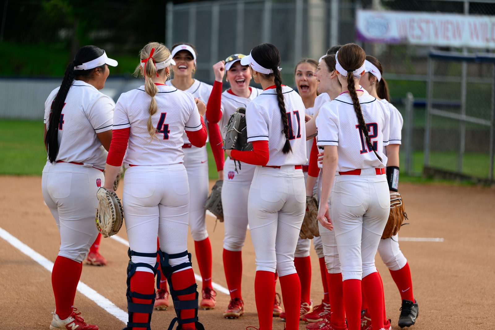 Westview softball team gather in a huddle near the baseline during a senior night game.